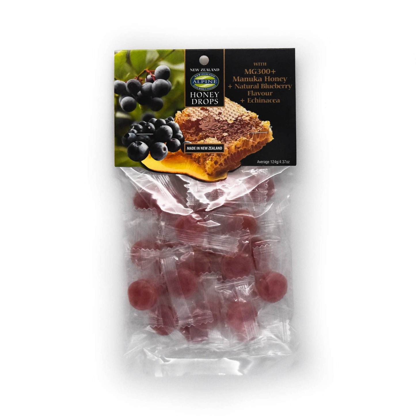 Image of a white backdrop with a packet of Blueberry Manuka Honey drops. The packaging is clear and you can see the purple-blue drops. The top of the packaging is a cardboard header that is black with a photo of blueberries and manuka honeycomb. there is also text.