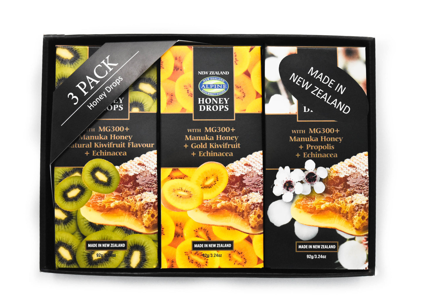 image on white backdrop. Image is of a black box holding 3x Manuka Honey drops in flavours left to right; kiwifruit, gold kiwifruit and propolis. Each is individually boxed in their own packaging. There is a 3 pack honey drops sign and a made in New Zealand sticker.
