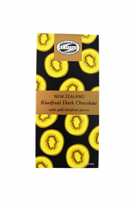 Image of a black chocolate bar with gold kiwifruit slices scattered. 