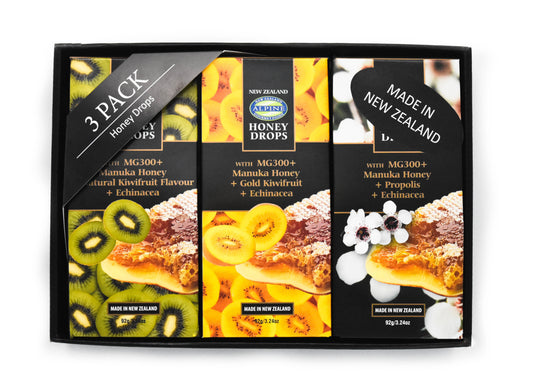 image on white backdrop. Image is of a black box holding 3x Manuka Honey drops in flavours left to right; kiwifruit, gold kiwifruit and propolis. Each is individually boxed in their own packaging. There is a 3 pack honey drops sign and a made in New Zealand sticker. 