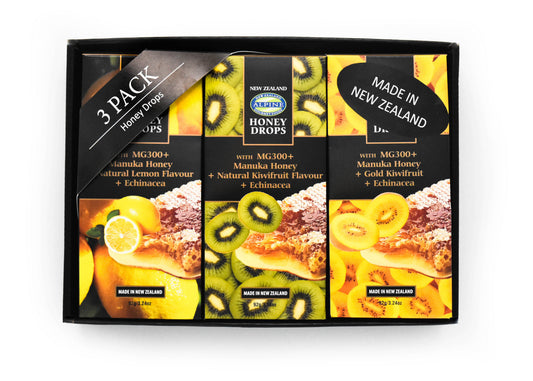 Giftbox on a white background. Box is black with 3 pouches of honey drops in different flavours. Left to right Lemon, Kiwifruit and Golden Kiwifruit with artwork to describe. Label with 3 pack honey drops and sticker with Made in New Zealand. 