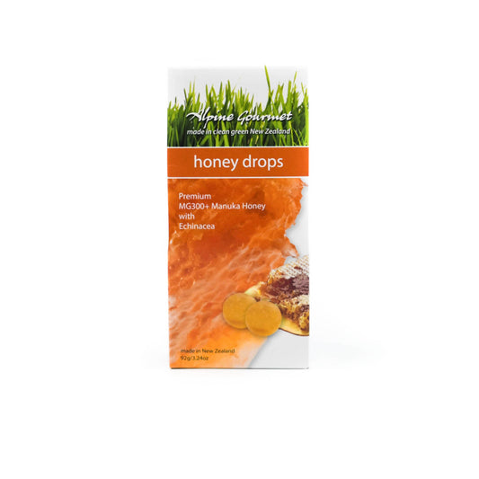 Packaging of Mănuka Honey Drops with Echinacea showing the product name, an image of honey drops, and a background of grass and flowers.