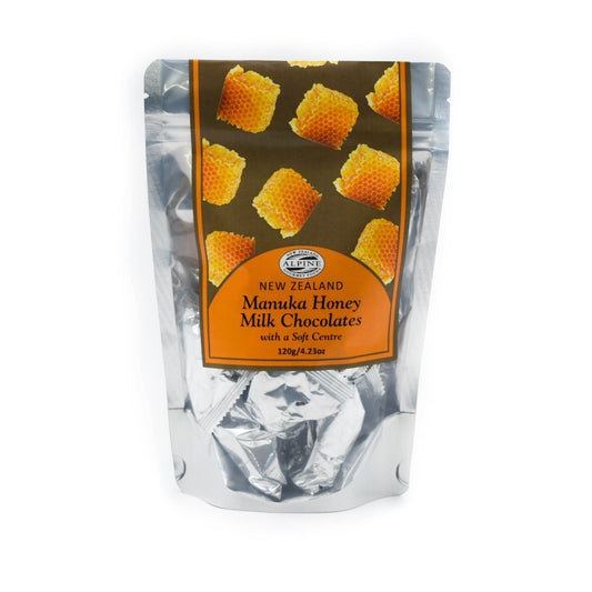 Packaging of premium milk chocolates with Mānuka honey centre, showing the chocolates individually wrapped in a clear packaging  and the label indicating New Zealand origin and Mānuka honey content.